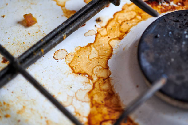 Close-up of using baking soda and vinegar to dissolve burnt-on grease on stove